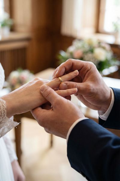 Braut bekommt Trauring angesteckt Detailaufnahme